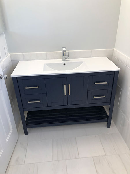 marble tile bathroom floor and dark blue vanity with white top